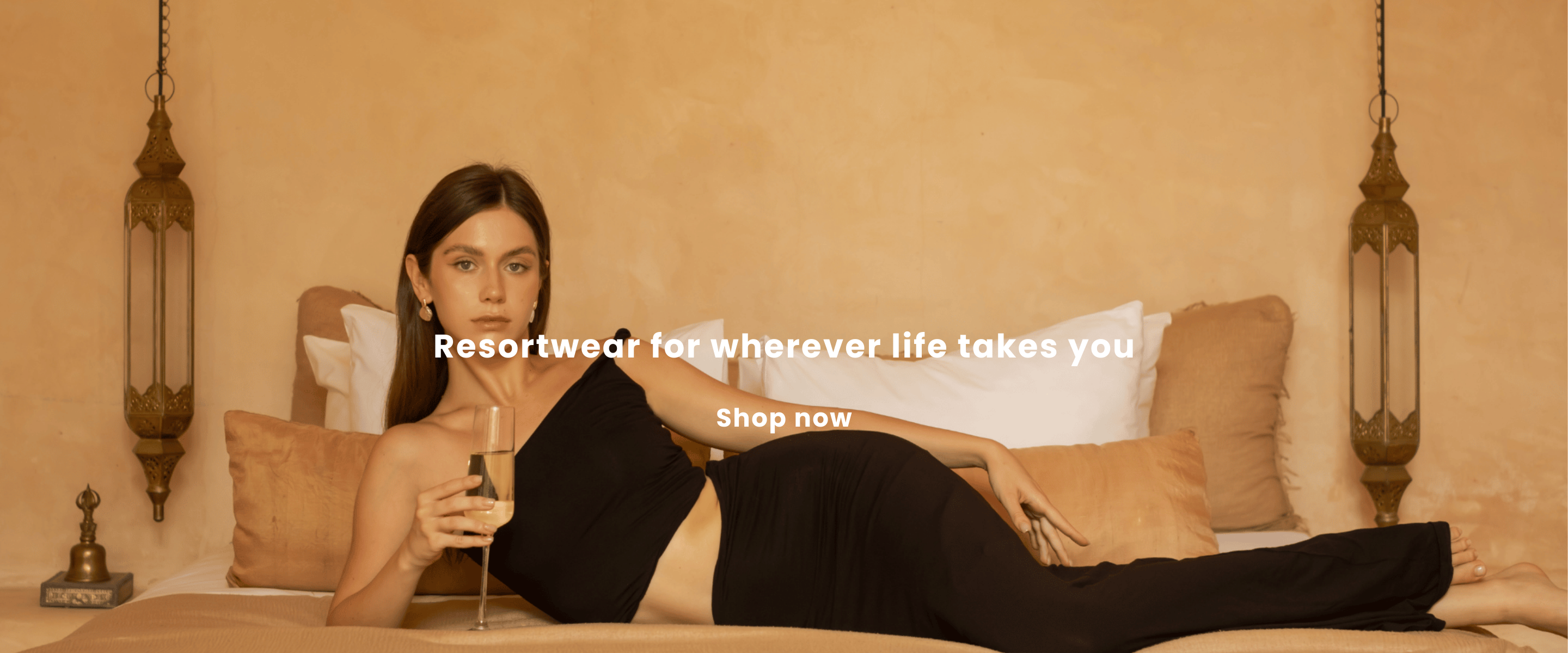Woman in black top and skirt sitting on a bed with text overlay in a bedroom setting